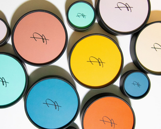 Cylindrical containers with colorful lids for the Earth & Ember line