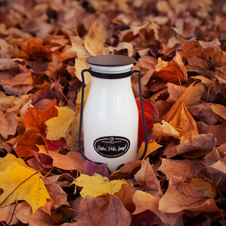 14 oz white milk bottle with black lid labeled 'Rake, Pile, Leap!' on a bed of autumn leaves