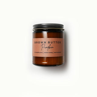 Amber colored classic statement jar with a 'Brown Butter Pumpkin' scented candle on a white background