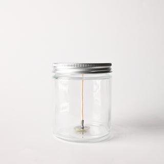 Clear glass jar with a metal lid on a white background