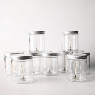 Set of clear glass jars with metal lids on a white background