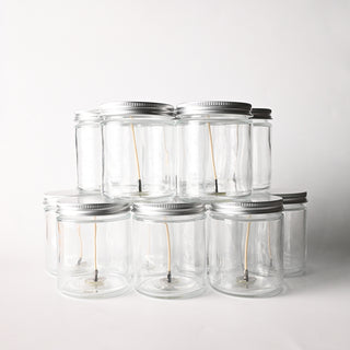 Clear glass jars with metal lids on a white background