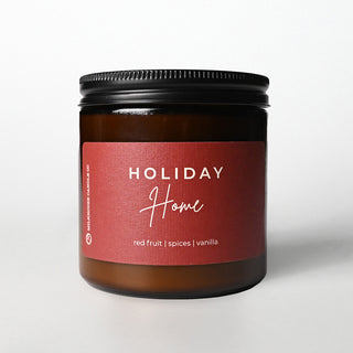 Brown candle jar with a red label on a white background