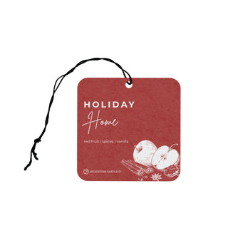 Red air freshener tag with 'Holiday Home' text and apple and cinnamon illustrations on a white background.