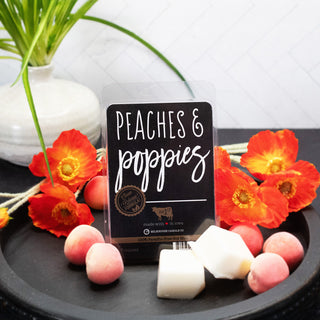 Peaches & Poppies wax melt package with flowers and peaches on a black surface