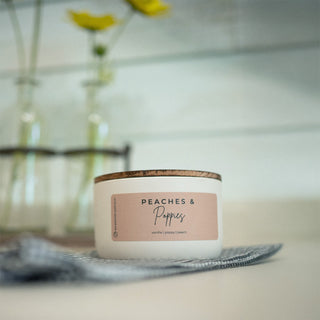 10 oz candle with 'Peaches & Poppies' label on a surface with a blurred background