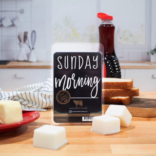 Package of wax melts labeled 'Sunday Morning' on a kitchen counter with bread and butter