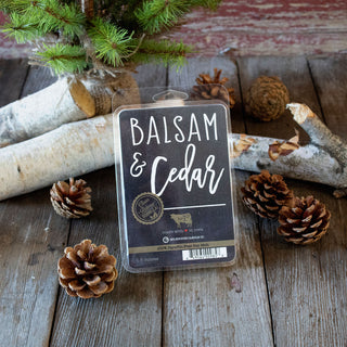 Balsam & Cedar wax melts package on a wooden surface with pine cones and logs