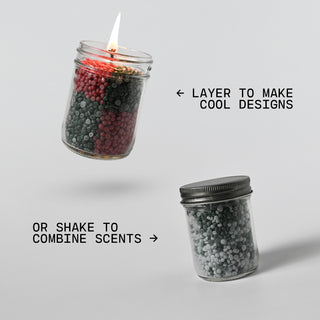 Two jars with lids, one containing a lit candle and layered wax beads, the other with a lid on a gray background
