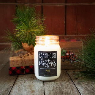 'Farmhouse Christmas' candle in a jar with decorative elements on a wooden surface