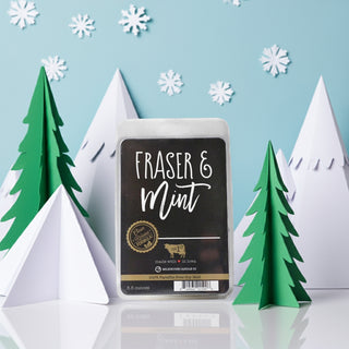 Wax melt package labeled 'Fraser & Mint' with decorative trees and snowflakes in the background