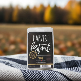 Harvest Festival wax melt package on a plaid fabric with a blurred autumn field background