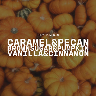 Text overlay on a pile of pumpkins background with product name of Hey, Pumpkin! and description of caramel & pecan, brown sugar & pumpkin and vanilla & cinnamon
