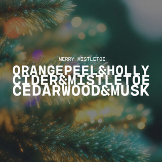 Text overlay on a blurred Christmas tree background with a scent listed of Merry Mistletoe and notes of orange peel & holly, cider & mistletoe and cedarwood & musk