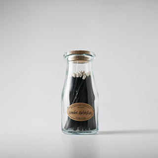 A jar of matches labeled 'Wooded Matchsticks' against a white background