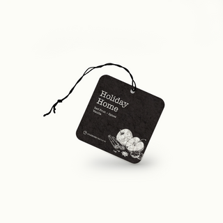 Black and white air freshener tag with 'Holiday Home' text on a white background
