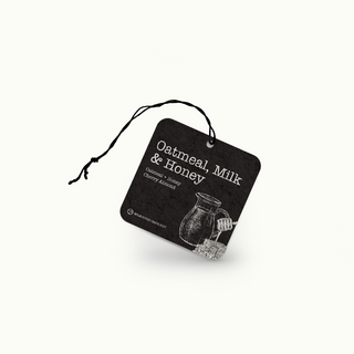 Black air freshener tag with 'Oatmeal, Milk & Honey' text and a pitcher illustration on a white background
