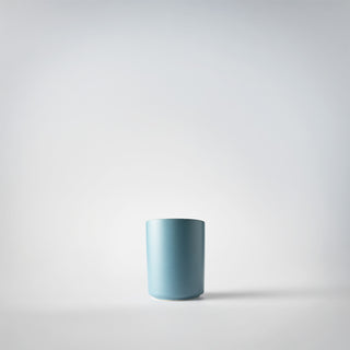 A votive sized blue container against a white background