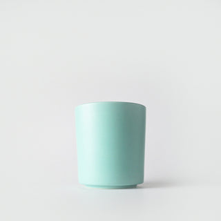 A seafoam green ceramic container against a white background