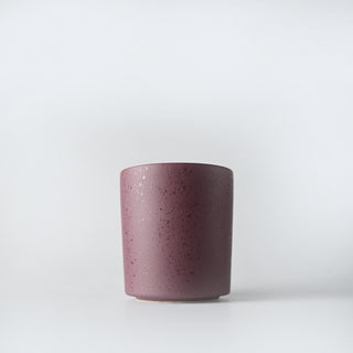 A burgundy flecked container against a white background
