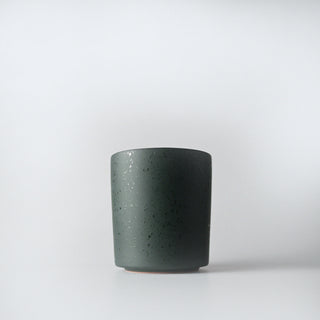 A flecked dark green colored container against a white background