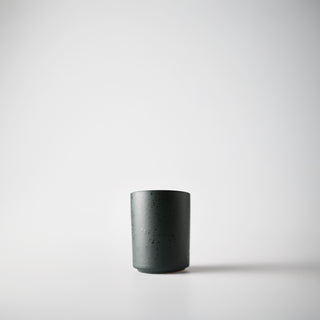 Close-up of a dark green textured votive 