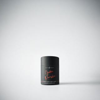 A petite black  candle holder with the text 'Golden Pumpkin' written in orange, displayed against a white background