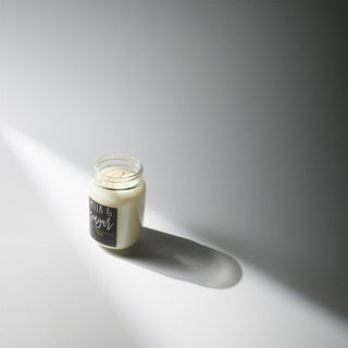 13 oz mason jar candle with a black label of 'Milk & Sugar' against a white background