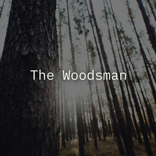 A sunlit forest with 'The Woodsman' in a white text overlay