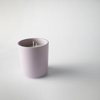Candle in a lavender colored container against a white background