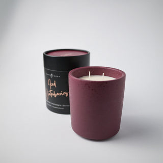 Flecked burgundy ceramic container with candle and holder labeled 'Iced Winterberries' against a white background