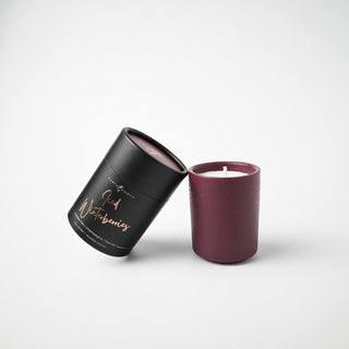 Flecked burgundy colored container with a candle and holder labeled 'Iced Winterberries' against a white background