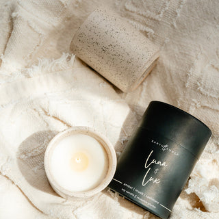Earth & Ember 'Luna & Lux' candles with canister on a textured cream surface