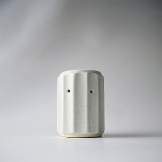A white ribbed column melter against a white background