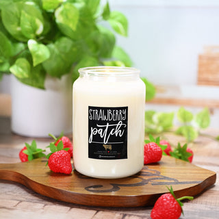 26 oz mason jar candle labeled 'Strawberry Patch' on a wooden board with strawberries and greenery in the background