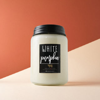 Candle jar labeled 'White Pumpkin' on a terracotta background